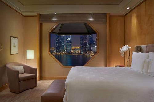 a hotel room with a large bed and a window at The Ritz-Carlton, Millenia Singapore in Singapore
