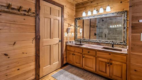 een badkamer met een dubbele wastafel en een spiegel bij Knotty By Nature in Blue Ridge