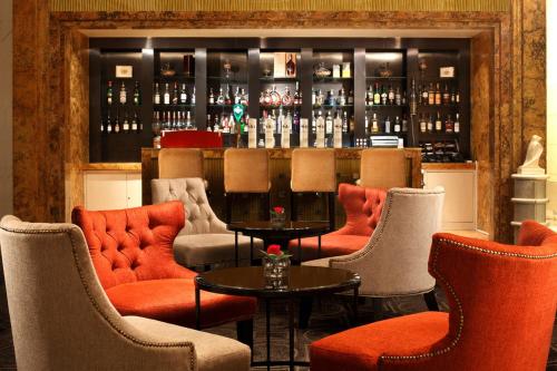 a bar with orange chairs and a counter with bottles at Sheraton Shenzhen Futian Hotel in Shenzhen