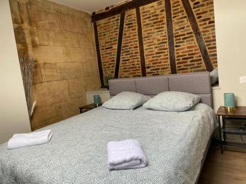 a bedroom with a bed with two towels on it at Studio Charme Ardennais in Charleville-Mézières