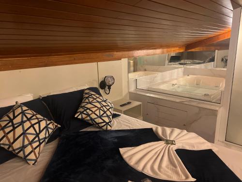 a room with a bed and a tub on a boat at Lofts do Pilar - pousada in Ouro Preto