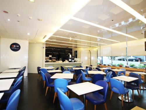 a dining room with tables and blue chairs at Holiday Inn Express Taoyuan by IHG in Taoyuan