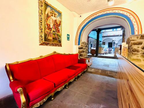 a red couch in a room with a painting on the wall at Rojas Plaza Boutique in Cusco