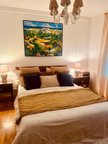 a bedroom with a large bed with a painting on the wall at Casa Jana Croatia in Jastrebarsko