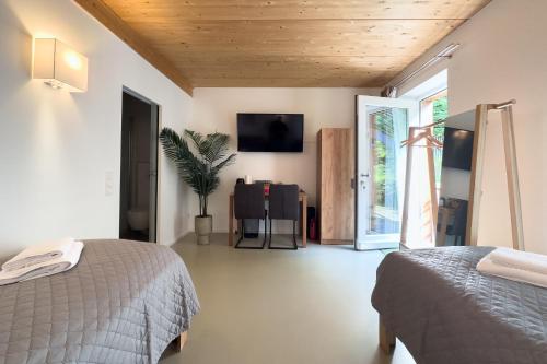una camera da letto con due letti e una TV a parete di Ruhige Apartments mit guter Bahnanbindung und Küchennutzung a Rösrath