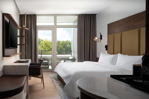 um quarto de hotel com uma cama e uma janela em Ada Hotel em Ada