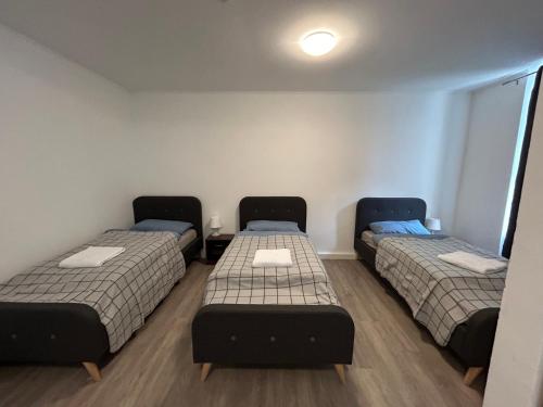 a room with three beds in a room at Gera Apartment EG in Gera