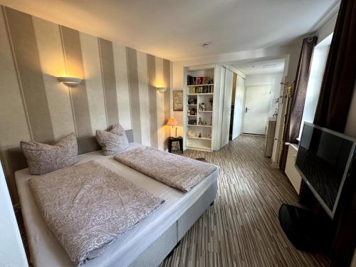 a bedroom with a white bed and a television at Stadtzauber in Malchow