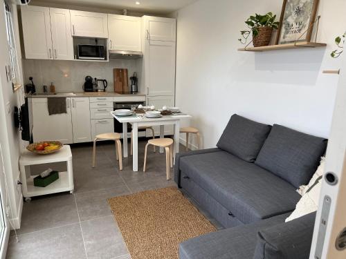 un petit salon avec un canapé et une table dans l'établissement Bas de Villa 2P, Grande Terrasse, Vue mer, Plage à 15mn, à Saint-Laurent-du-Var