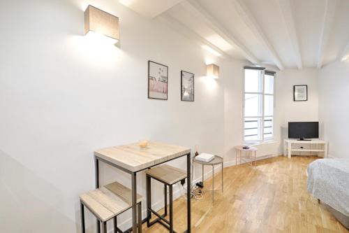 un salon avec une table et des chaises et un lit dans l'établissement Seine - Best localisation - Bail mobilité, à Paris