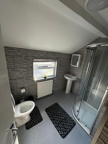 a bathroom with a shower and a toilet and a sink at Amirs house reed ave in Kent