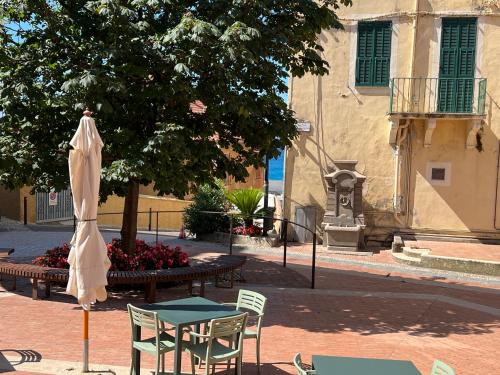 a table and chairs and an umbrella on a street at La Rosa Dei Venti, Centro Storico, 50 metri dalle Spiagge in Ospedaletti