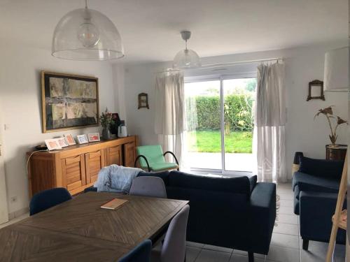 ein Wohnzimmer mit Couch und Tisch in der Unterkunft Maison dans le sud du Morbihan près de la mer in Damgan