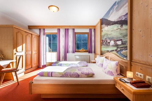 トゥクスにあるHaus Windeggのベッドルーム1室(ベッド2台付)が備わります。壁には絵画が飾られています。