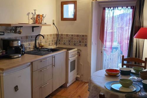 une cuisine avec une table et un comptoir dans l'établissement Le Studio des Voyageurs, à 2 pas de la Gare, à Carcassonne