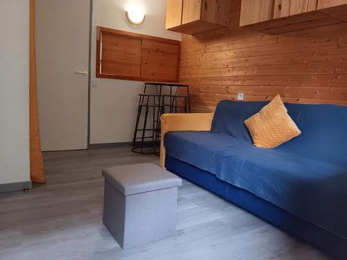 - un salon avec un canapé bleu et un tabouret dans l'établissement Appartement Valfrejus Les Melezets1 21m2 centre station, à Modane