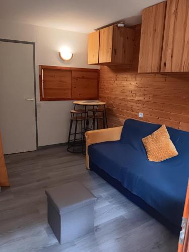 - une chambre avec un lit bleu et une table dans l'établissement Appartement Valfrejus Les Melezets1 21m2 centre station, à Modane