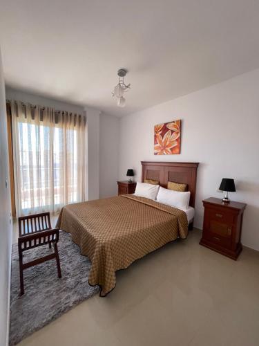 ein Schlafzimmer mit einem Bett und einem Stuhl und einem Fenster in der Unterkunft Villa Matilde in San Luis de Sabinillas