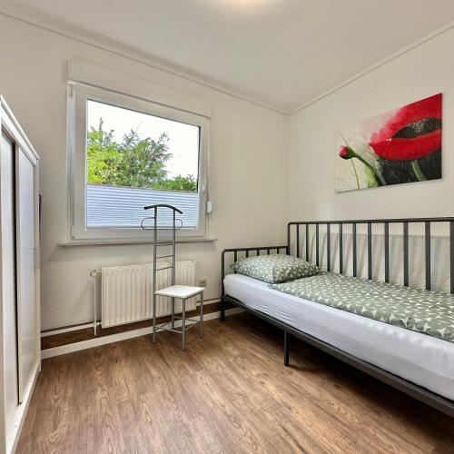 a bedroom with a bed and a window at Moin Moin - Garden Apartment in Wildeshausen