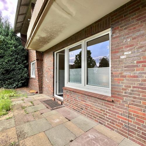 a brick house with a window and a patio at Moin Moin - Garden Apartment in Wildeshausen