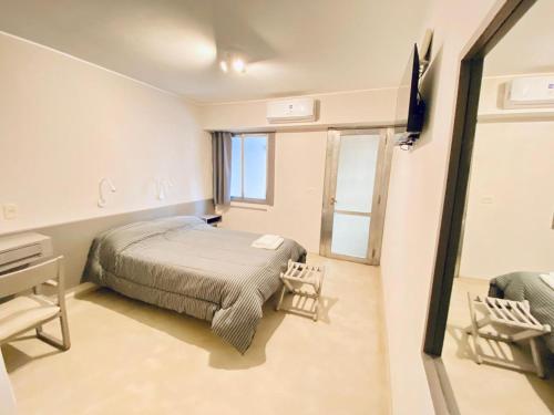 a bedroom with a bed and a desk and a mirror at ALWA Suites in Resistencia