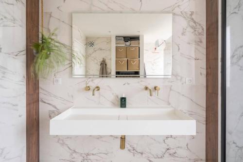 une salle de bain avec un lavabo blanc et un miroir dans l'établissement Le Skyview - Vue sur Lyon, à La Mulatière