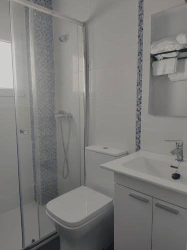 a white bathroom with a toilet and a shower at Apartamento El Rincón del Nela in Villarcayo