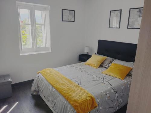 a bedroom with a bed with yellow pillows and a window at Apartamento El Rincón del Nela in Villarcayo
