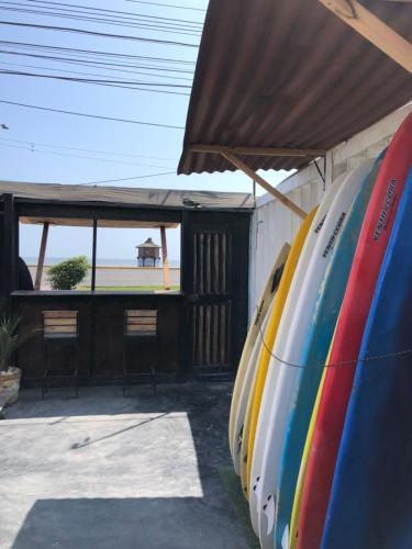 a row of surfboards lined up against a building at Pointbreak Surf Camp in Huanchaco