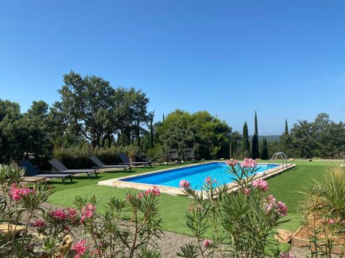- une piscine dans une cour agrémentée de bancs et de fleurs dans l'établissement Les Terra Rossa, Villa contemporaine proche Lacs et Gorges du Verdon, à Aups