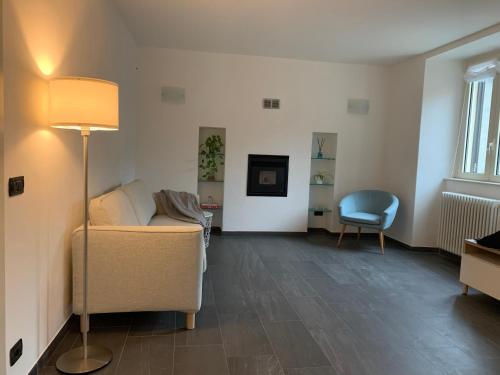 een woonkamer met een bank en een stoel bij Spazio Perlasca Apt 1 - Cernobbio Como Lake in Cernobbio