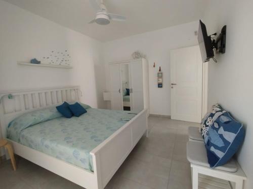 een witte slaapkamer met een bed en een televisie bij Casa Vacanze Pesce Palla in Villaggio Azzurro