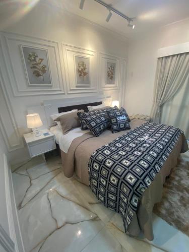a bedroom with a large bed and a table and lamps at Flat Beira Mar Piedade 1603 in Recife