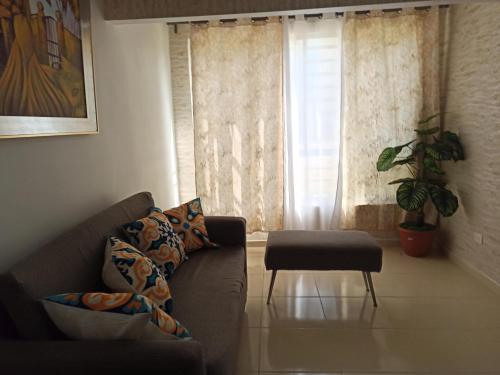 a living room with a couch and a chair and a window at Apartamento en Ciudad Juan Bosch in La Javilla