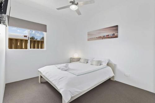 Un dormitorio blanco con una cama y un ventilador de techo. en Vasse Manor, en Vasse
