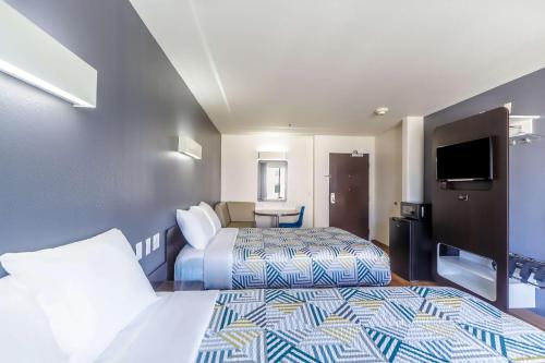 a hotel room with two beds and a flat screen tv at Motel 6-Laredo, TX - Airport in Laredo