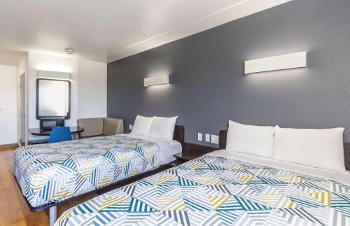 a hotel room with two beds and a chair at Motel 6-Laredo, TX - Airport in Laredo