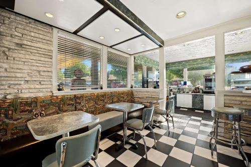 a restaurant with tables and chairs and a brick wall at Best Western Route 66 Rail Haven in Springfield