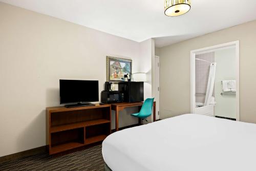 a room with a bed and a desk with a television at Best Western Route 66 Rail Haven in Springfield