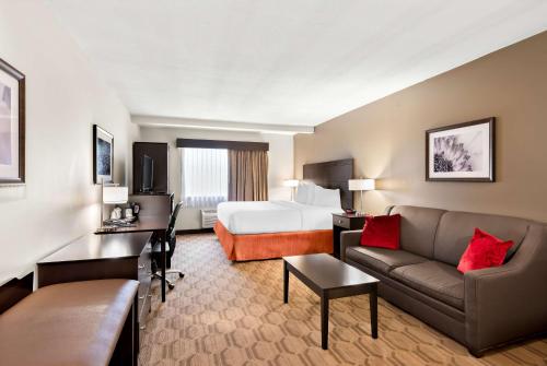 a hotel room with a bed and a couch at Best Western Palmyra Inn & Suites in Palmyra