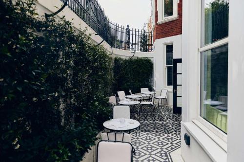 a patio with tables and chairs on a building at At Sloane in London