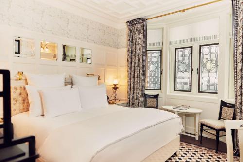 a bedroom with a large white bed and windows at At Sloane in London