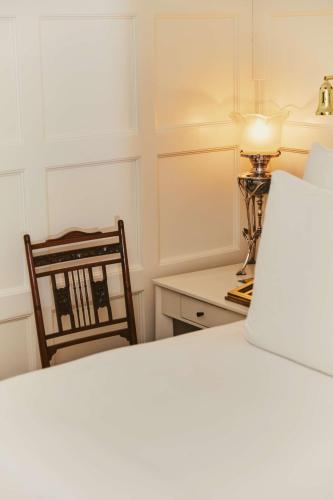 a bedroom with a bed and a desk with a lamp at At Sloane in London