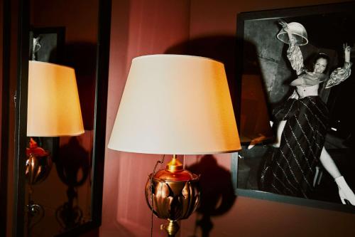two lamps in a room with a picture of a woman at At Sloane in London