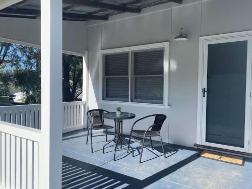 a patio with chairs and a table on a porch at Yaringa Cottage by the sea in Busselton