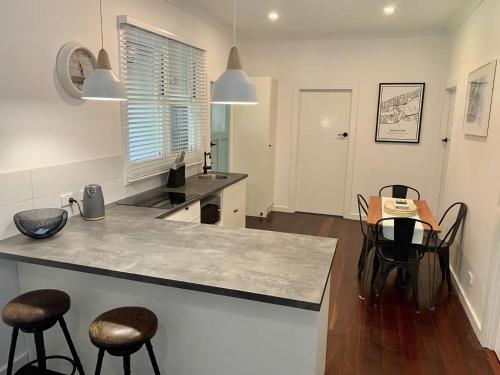 a kitchen with a counter and a table and chairs at Yaringa Cottage by the sea in Busselton