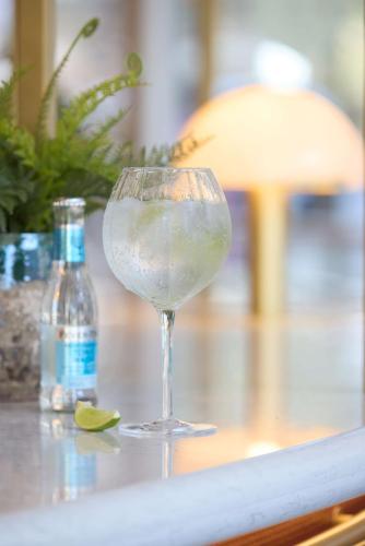 a glass of wine sitting on a table with a lime at DoubleTree by Hilton London Chelsea in London