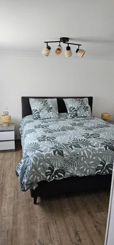 a bedroom with a bed with a green comforter at Appartement de 65m2 avec piscine partagée in Tremblay-En-France
