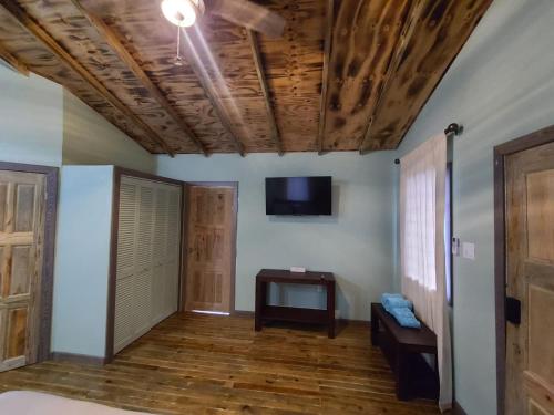 a room with wooden ceilings and a tv on the wall at Tuquil-HA in Ladyville
