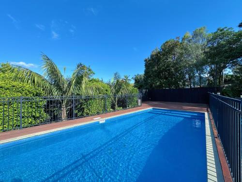 a swimming pool in front of a fence at The Ultimate Escape - Holiday Villa Private POOL in Auckland
